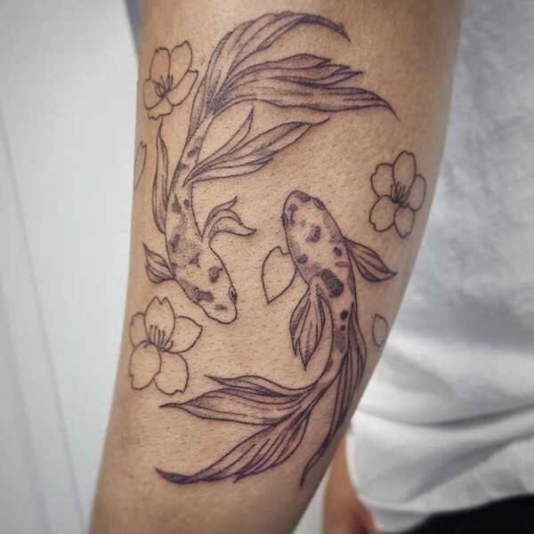 atticus tattoo, black and grey tattoo of two beta fish with cherry blossoms
