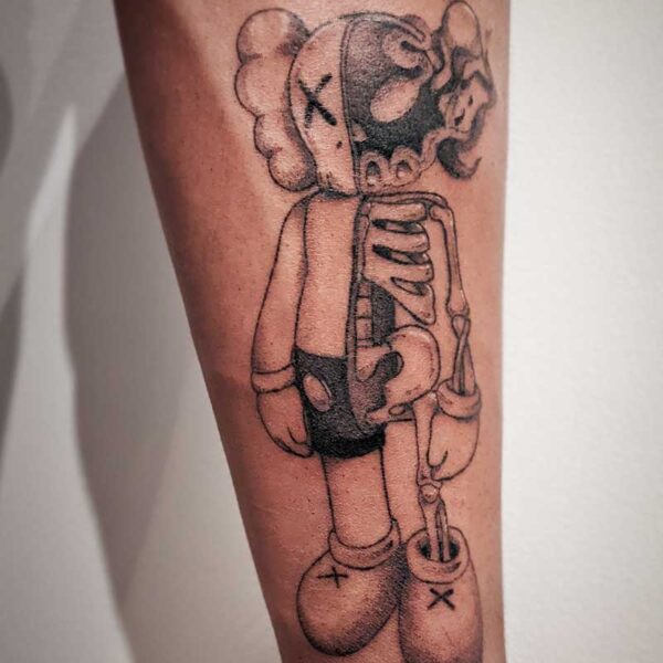 atticus tattoo, black and grey tattoo of a half doll, half skeleton