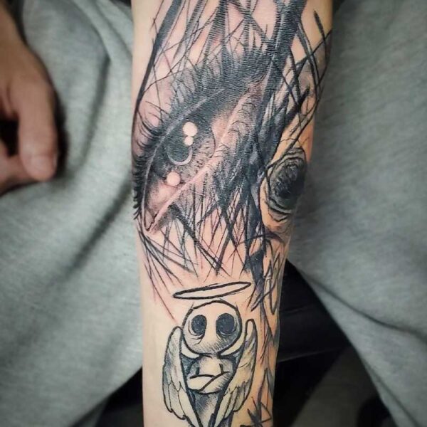 atticus tattoo, black chaos tattoo of an eye and cartoon angel
