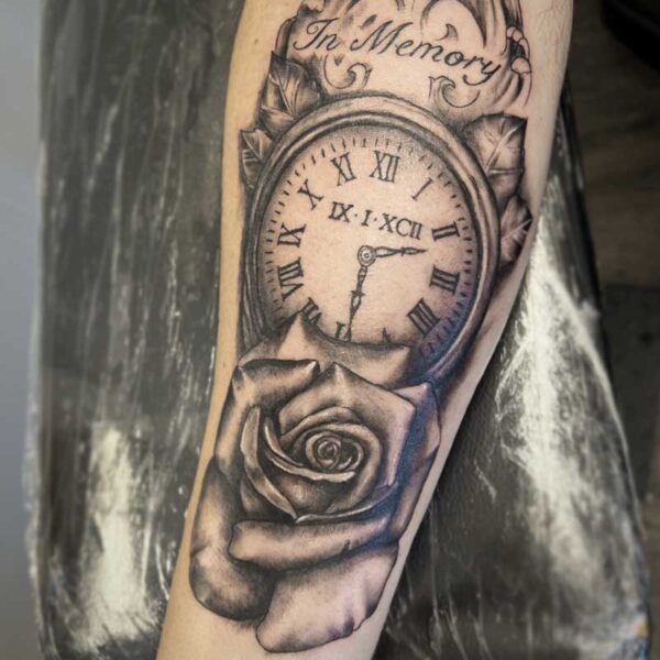 atticus tattoo, black and grey realism tattoo of a clock and rose