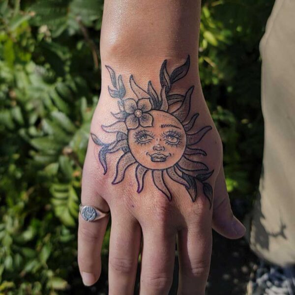 atticus tattoo, black and grey neotraditional tattoo of the sun with flowers