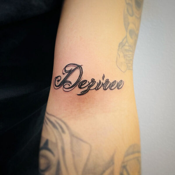 atticus tattoo, script tattoo of the name "Desiree"