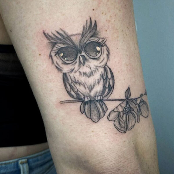 atticus tattoo, black and grey tattoo of a cartoon owl sitting on a branch of leaves