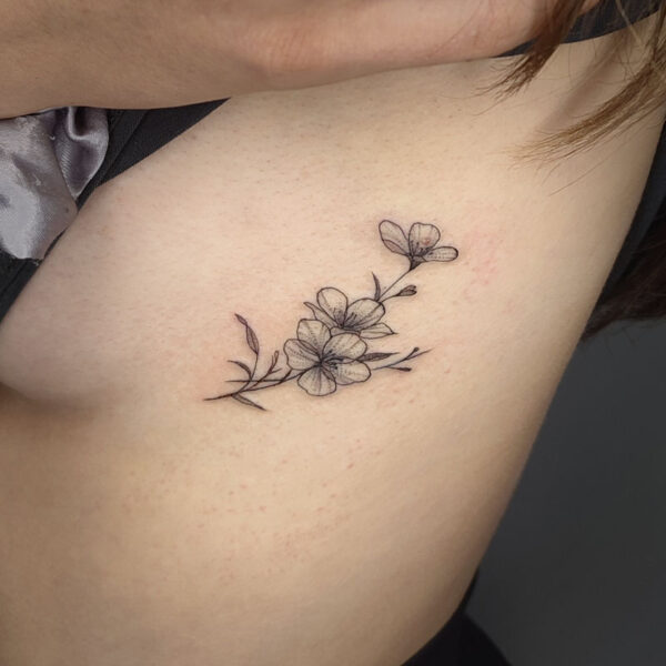 atticus tattoo, fine line tattoo of dainty flowers
