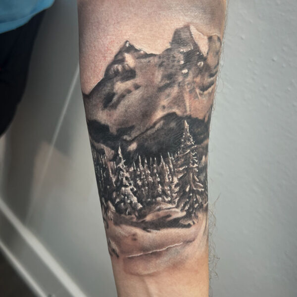 atticus tattoo, black and grey realism tattoo of a mountain scene