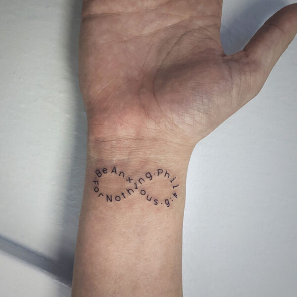 atticus tattoo, script tattoo in the shape of an infinity symbol