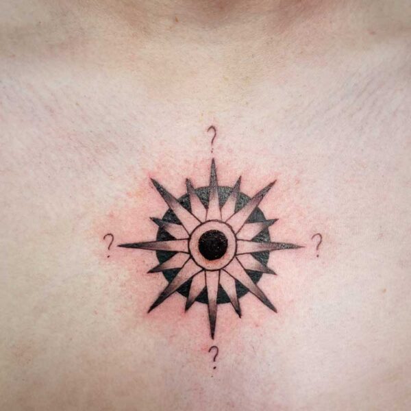 atticus tattoo, black and grey tattoo of a compass with question marks for the directions