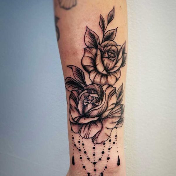 atticus tattoo, black and grey tattoo of roses with beads dangling from them