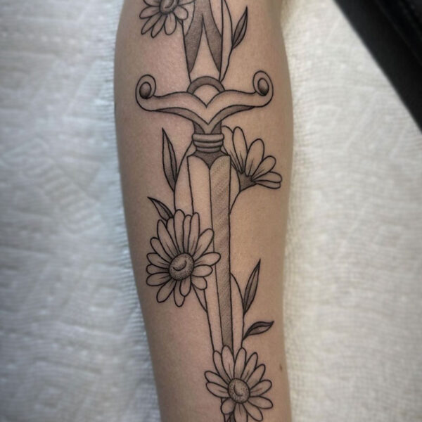 atticus tattoo, black and grey tattoo of a dagger with Daisies