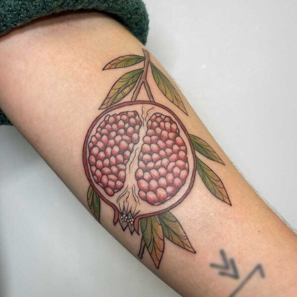 atticus tattoo; neotraditional tattoo of a pomegranate
