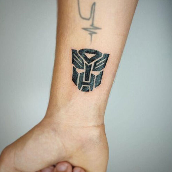 atticus tattoo, black tattoo of a transformer's symbol