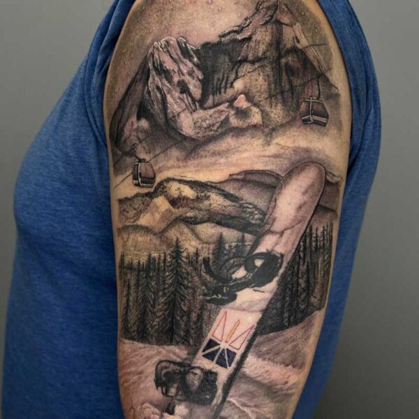 atticus tattoo; realism tattoo of a mountain scene and snowboard