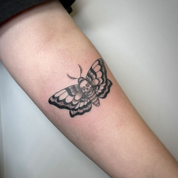 atticus tattoo, black and grey tattoo of a moth with a skull on its back
