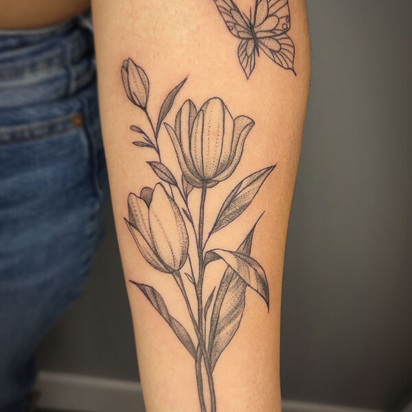 atticus tattoo, black and grey tattoo of tulips and a butterfly