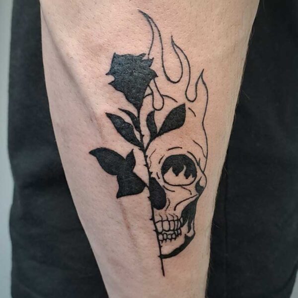 atticus tattoo, black tattoo of a rose and half a skull's face with flames