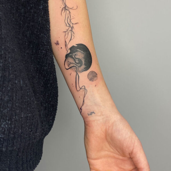 atticus tattoo; black and grey abstract tattoo of two planets with vines and flowers