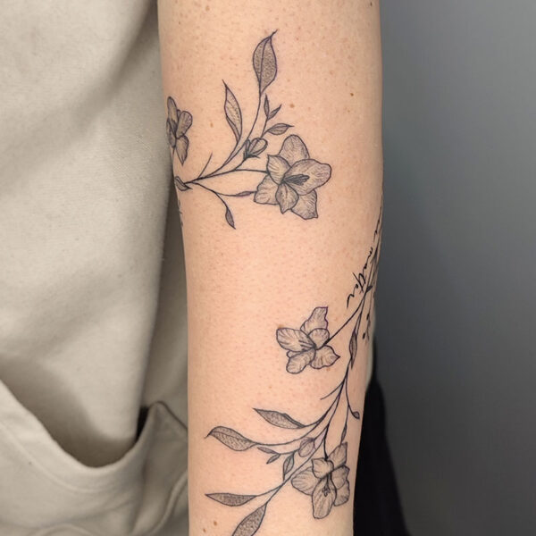 atticus tattoo, fine line tattoo of a vine of flowers