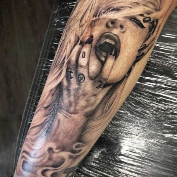 atticus tattoo, black and grey realism tattoo of a woman with her mouth open and grasping her face