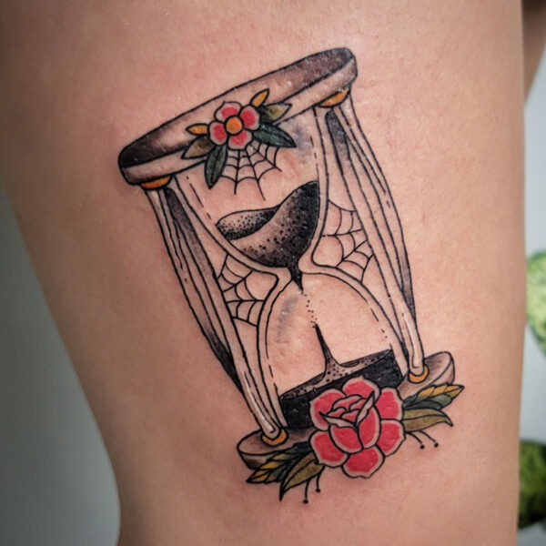 atticus tattoo, American traditional tattoo of an hour glass with flowers and spider webs