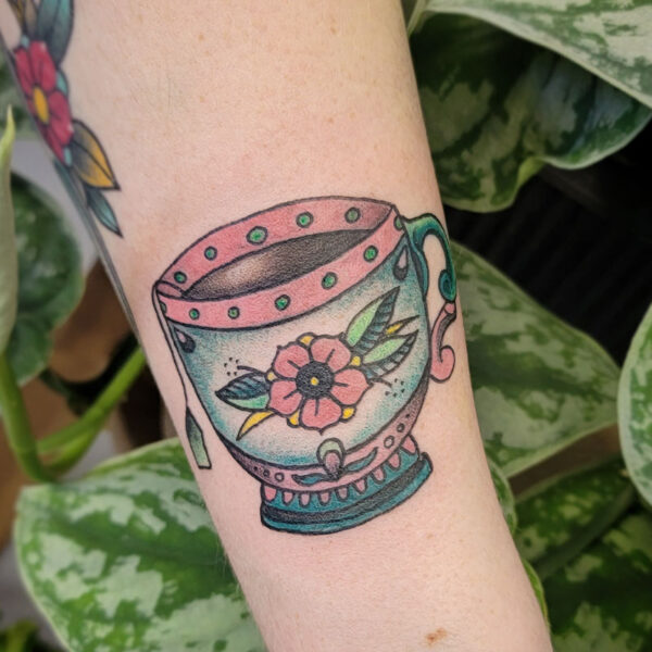 atticus tattoo, american traditional tattoo of a tea cup with a rose