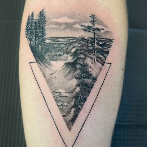 atticus tattoo, black and grey realism tattoo of a forest and lake scene, framed in a triangle