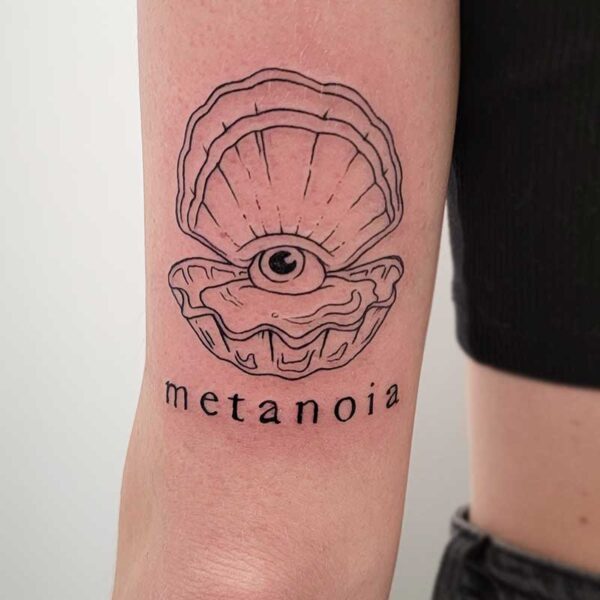 atticus tattoo, black and grey tattoo of an open clam with an eyeball inside and the word "metanoia"