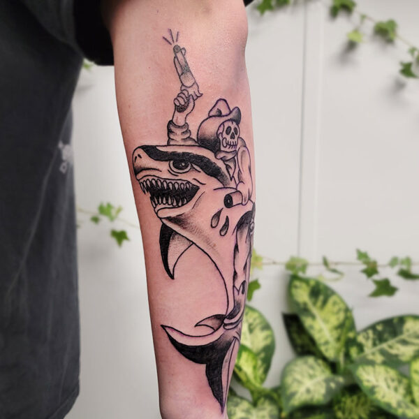 atticus tattoo, black and grey American traditional tattoo of a cowboy riding a shark