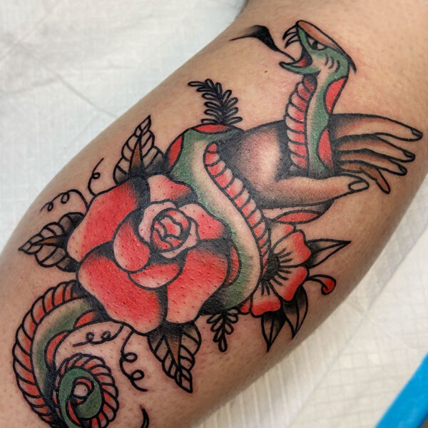 atticus tattoo, neotraditional tattoo of hand holding a snake that is wrapped around a rose
