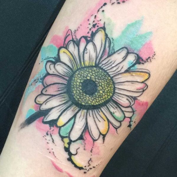 atticus tattoo, coloured tattoo of a daisy with pink's and blues splattered around it
