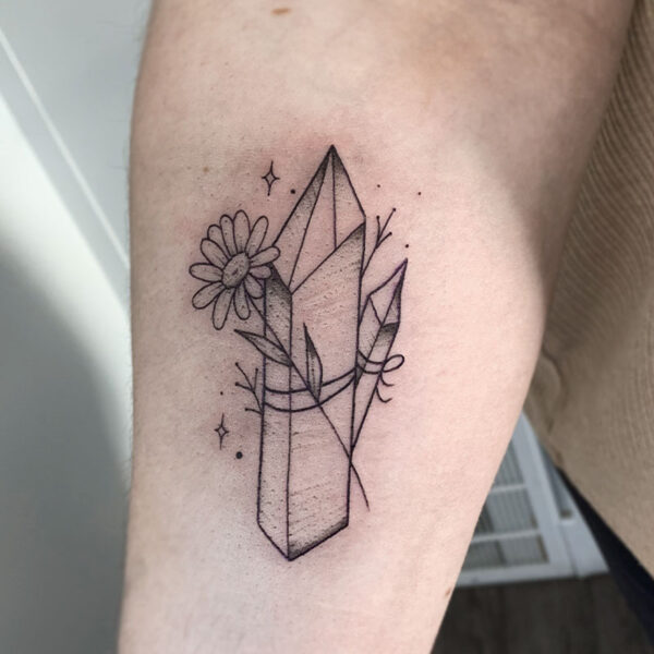 atticus tattoo, black and grey tattoo of crystals with a sunflower tied around them