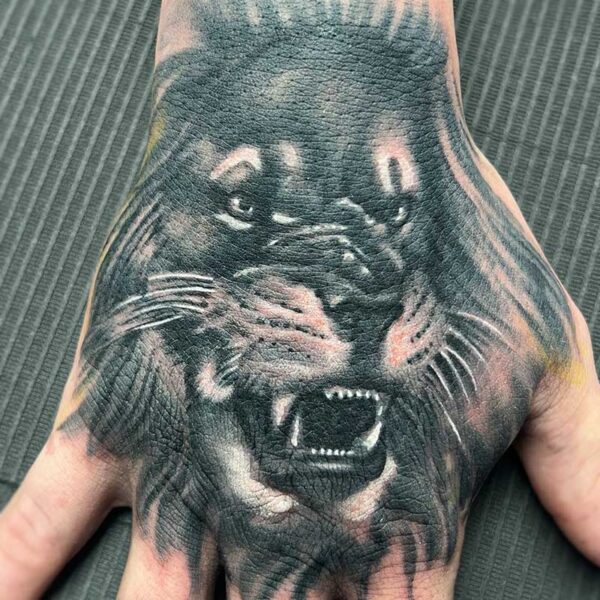 atticus tattoo, black and grey realism, hand tattoo of a lion