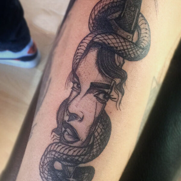 atticus tattoo, black and grey tattoo of a butcher knife with a woman's face reflecting in it and a snake wrapping around it