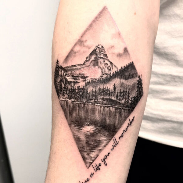 atticus tattoo, black and grey, realism tattoo of a mountain scene within a diamond shape