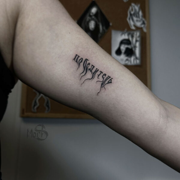 atticus tattoo, black and grey tattoo of a word that is bleeding ink