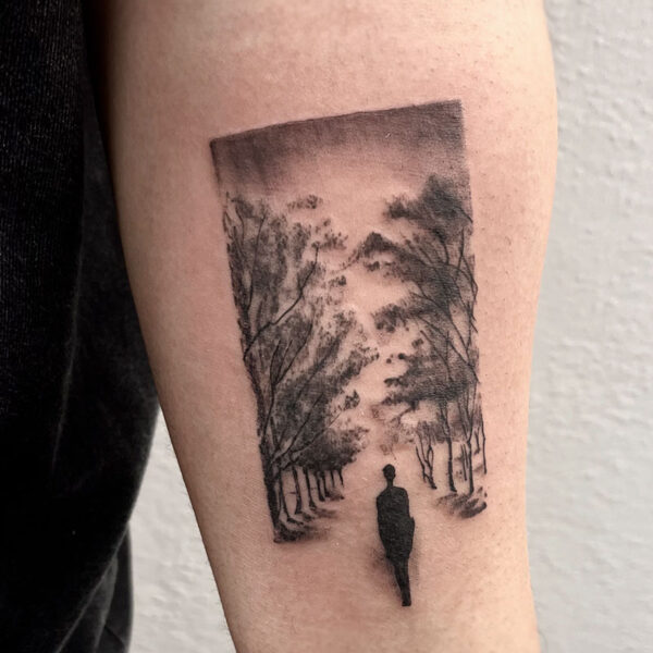 atticus tattoo, black and grey, realism tattoo of a person walking through rows of trees