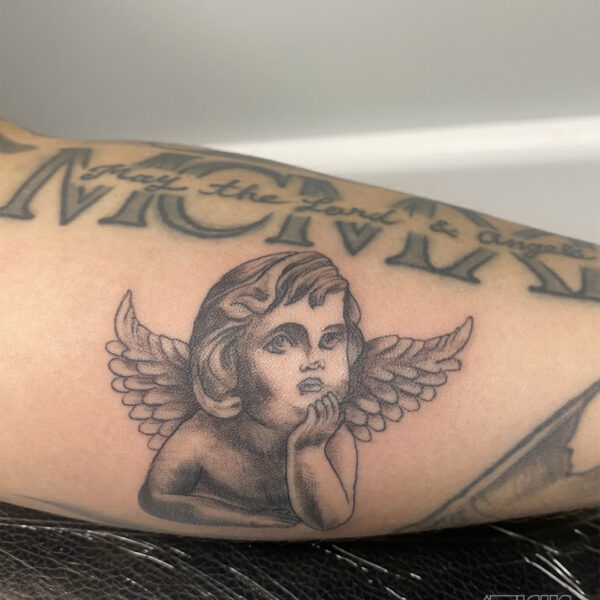 atticus tattoo, black and grey tattoo of a cupid