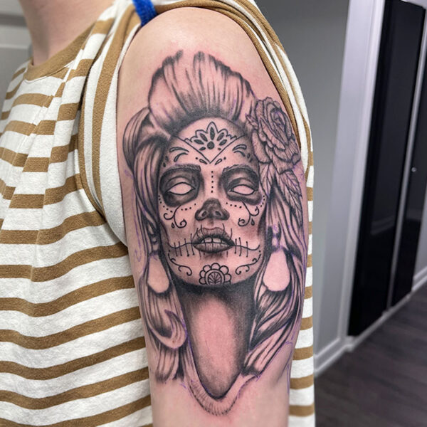 atticus tattoo, black and grey realism tattoo of a woman with a sugar skull face and roses