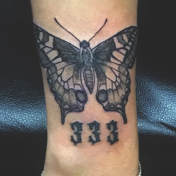 atticus tattoo, black and grey realism tattoo of a butterfly and the number 333