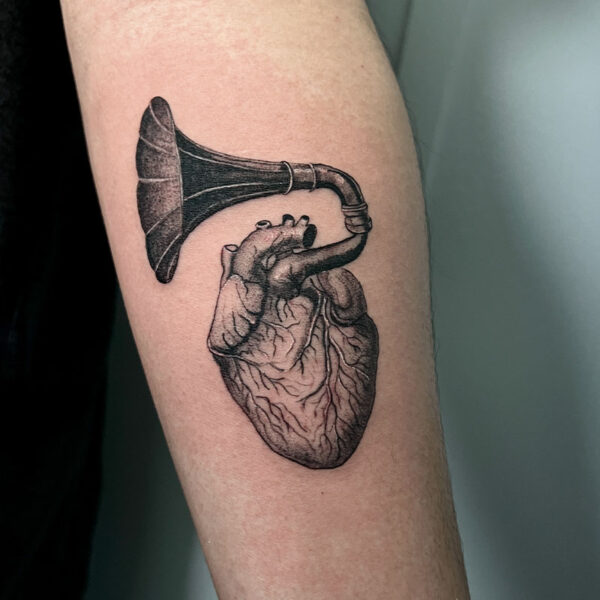 atticus tattoo, black and grey realism tattoo of a heart with a gramophone coming out of it