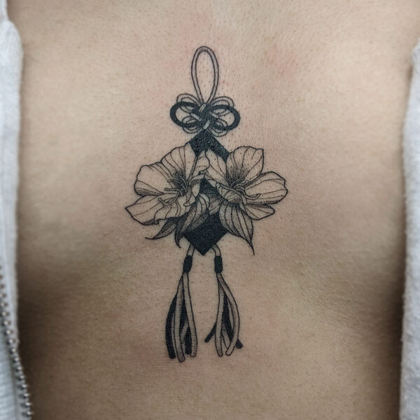 atticus tattoo, black and grey tattoo of flowers over a pendant with string