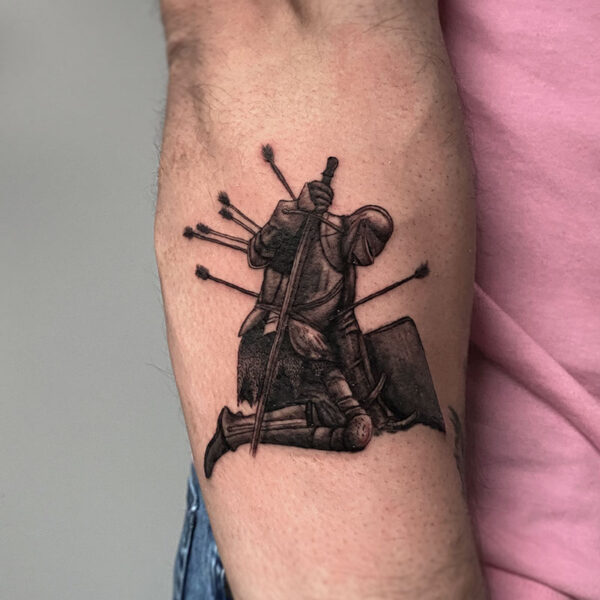 atticus tattoo, black and grey realism tattoo of a fallen soldier in armour with a sword, shield and with arrows in his body