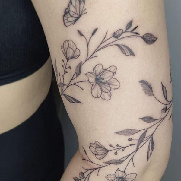 atticus tattoo, fine line tattoo of a vine of flowers with a butterfly