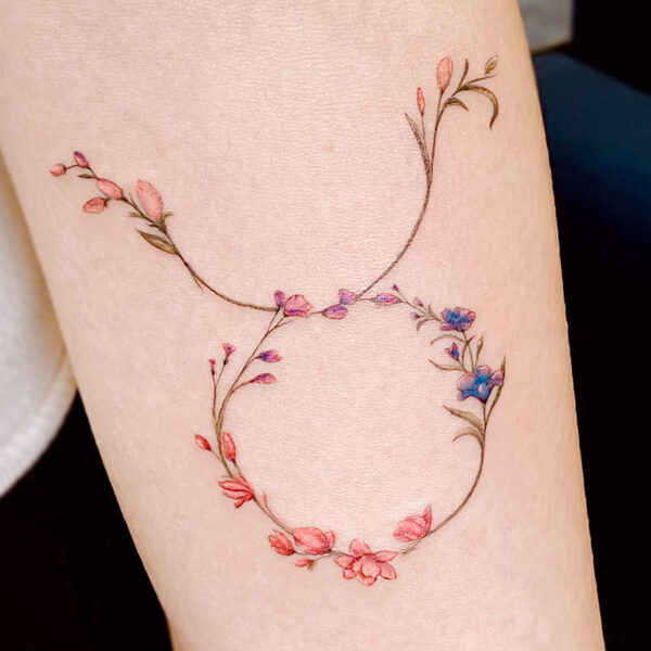 atticus tattoo, fine line tattoo of a circle of vines with small pink and blue flowers