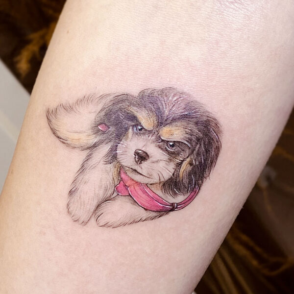 atticus tattoo, coloured tattoo of a small brown and white dog with a pink scarf