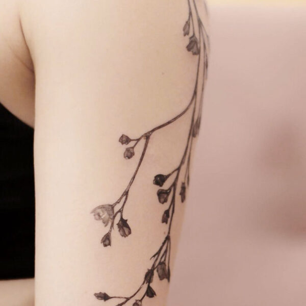 atticus tattoo, black and grey tattoo of a vine of flowers