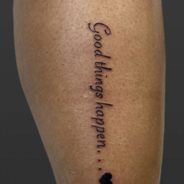 atticus tattoo, script tattoo of the words "good things happen" and a small heart