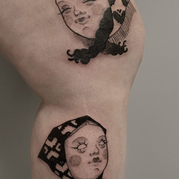atticus tattoo, black and grey tattoo of two doll faces with braids and wearing scarves