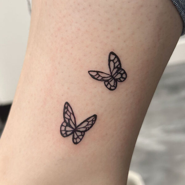atticus tattoo, tattoo of two small, black ink butterflies