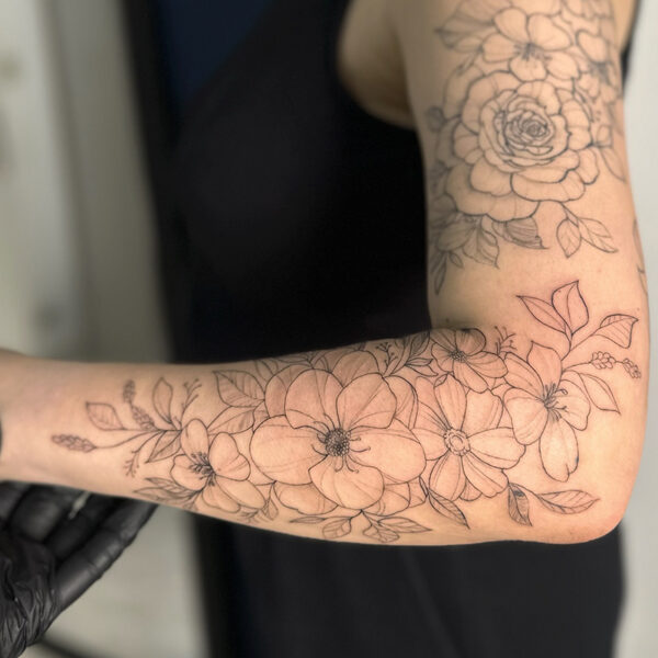 Fine line tattoo of a sleeve of florals