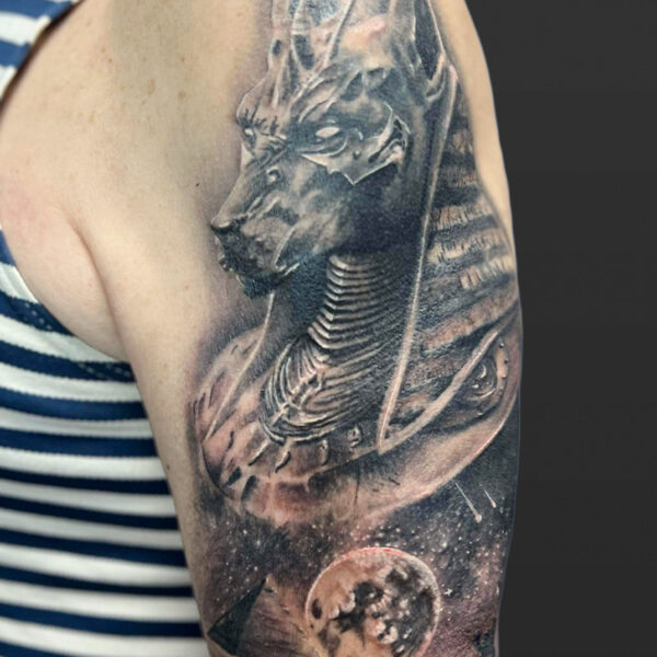 Atticus Tattoo| Black and grey, realism tattoo of Anubis over top the pyramids and a full moon